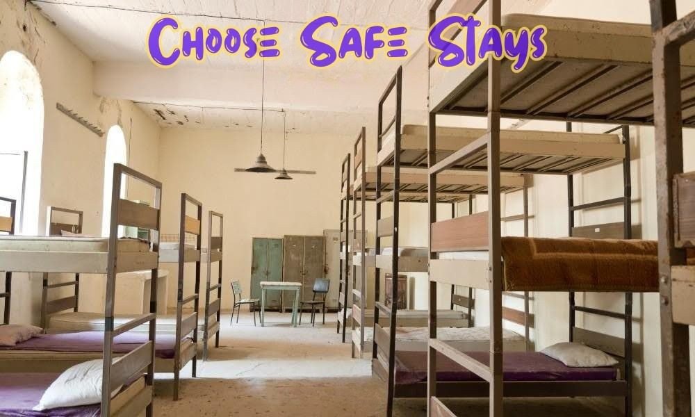 A clean hostel dormitory with metal bunk beds and lockers, essential for applying these Solo Female Travel Safety Tips on trips.