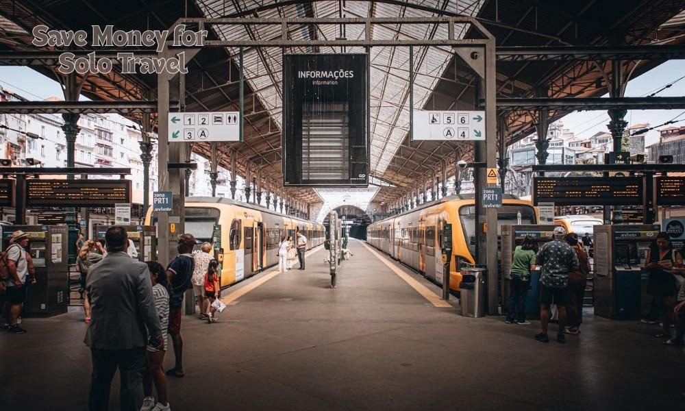 Travelers at a train station using public transport to save money while traveling solo